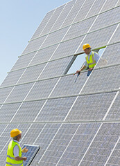 Workers examining solar panels