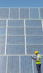Worker examining solar panels