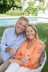 Senior couple drinking wine in backyard