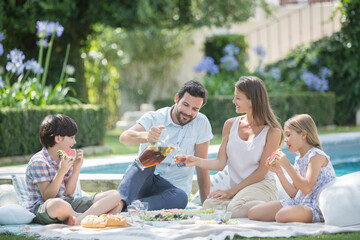 Family enjoying picnic at poolside