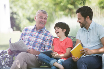 Multi-generation men laughing on bench