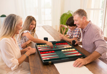 Grandparents and grandchildren playing backgammon