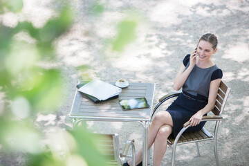 Businesswoman sitting at sidewalk cafe