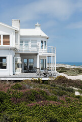 Beach house overlooking ocean - obrazy, fototapety, plakaty