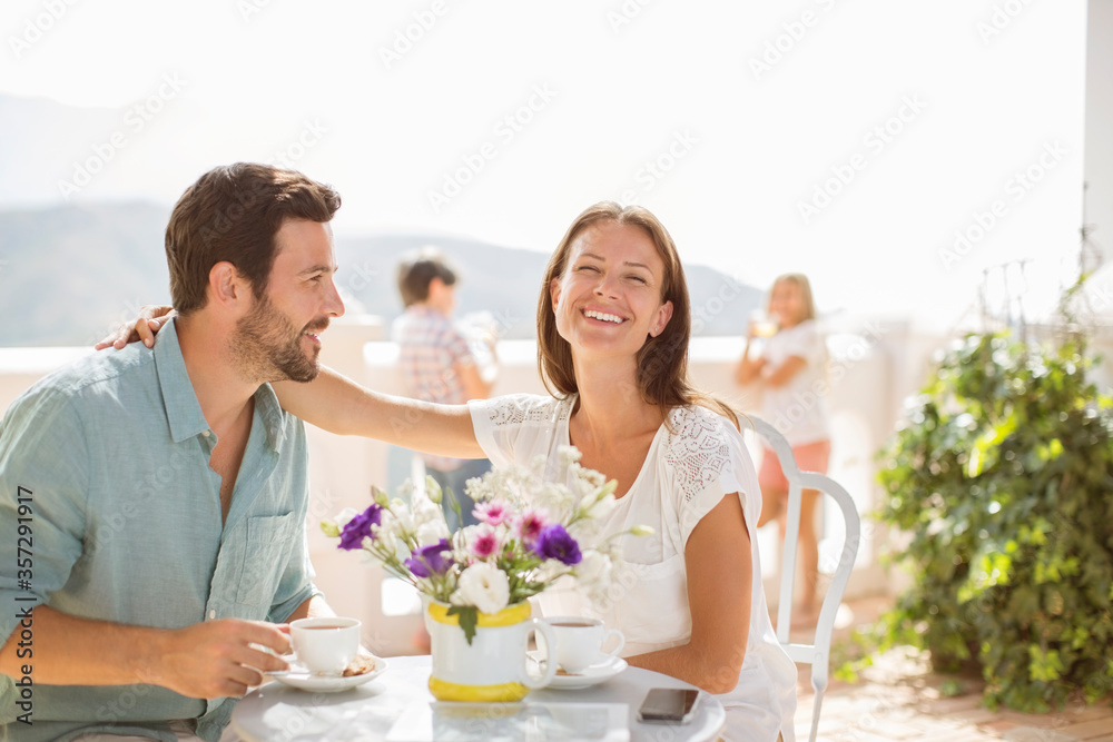 Wall mural Couple enjoying coffee on balcony