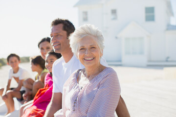 Multi-generation family smiling outside beach house