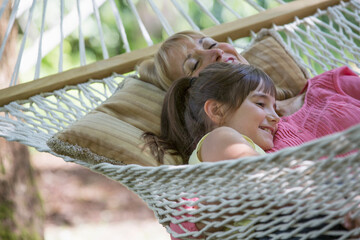 Woman and granddaughter relaxing in hammock