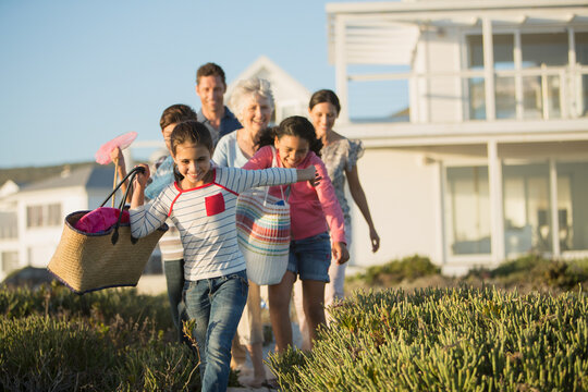Family walking on beach path outside house