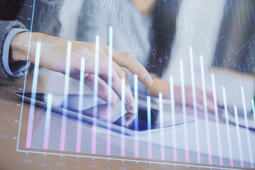 Double exposure of forex graph drawing and man and woman working together holding and using a mobile device. Trade concept.