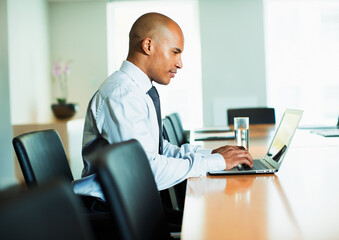 Businessman using laptop at conference table