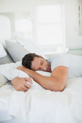 Obraz na płótnie Canvas Man hugging pillow on bed