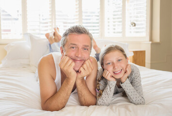 Father and daughter laying on bed