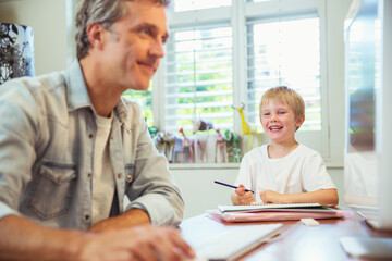 Father and son working in home office