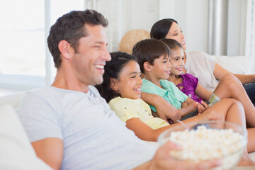 Family watching TV on sofa