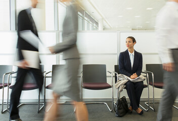 Businesswoman sitting in busy waiting area