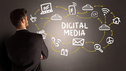 businessman drawing social media icons with DIGITAL MEDIA inscription, new media concept