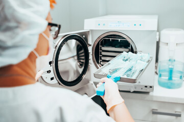 Autoclaving - Sterilization of medical instruments - a nurse loads a tray of instruments for...