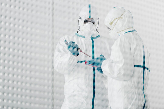 Scientists in clean suits working in laboratory