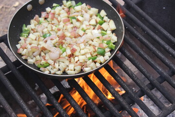 potato ,egg and ham breakfast cooking over campfire