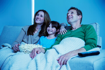 Family watching television in living room