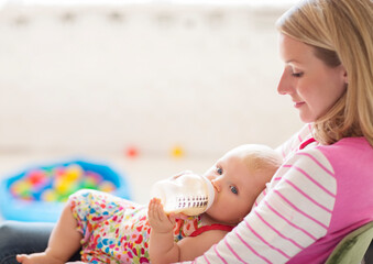 Mother feeding baby girl from bottle