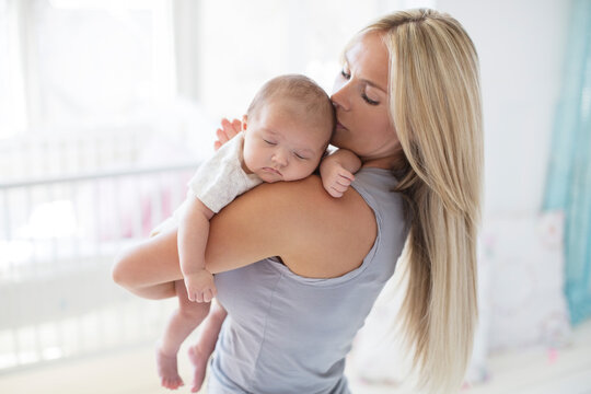 Mother Carrying Sleeping Baby Girl