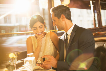 Man proposing to girlfriend in restaurant