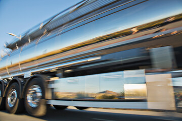 Blurred view of stainless steel milk tanker on the move