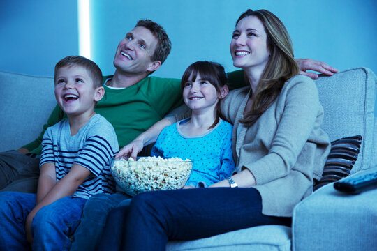 Family Watching Television In Living Room