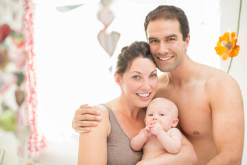 Parents and baby girl smiling together