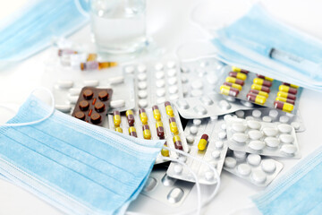 Coronavirus medicines and protective medical masks for staff on a white background.