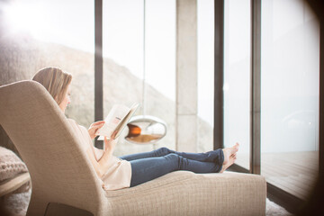 Woman reading on sofa in modern living room