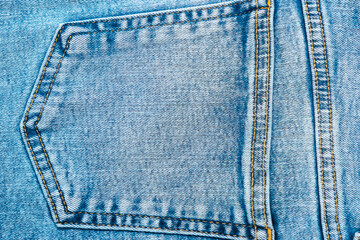 Close-up pocket of denim blue fabric with yellow seams