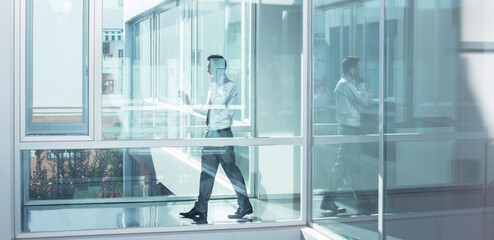 Businessman talking on cell phone in office corridor