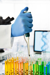 Close up of scientist pipetting solution into test tubes in lab