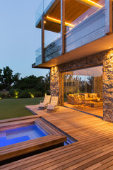 Modern house overlooking swimming pool and wooden deck