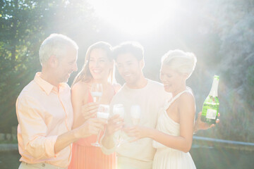 Friends toasting each other with champagne outdoors