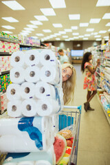 Woman pushing full shopping cart in grocery store