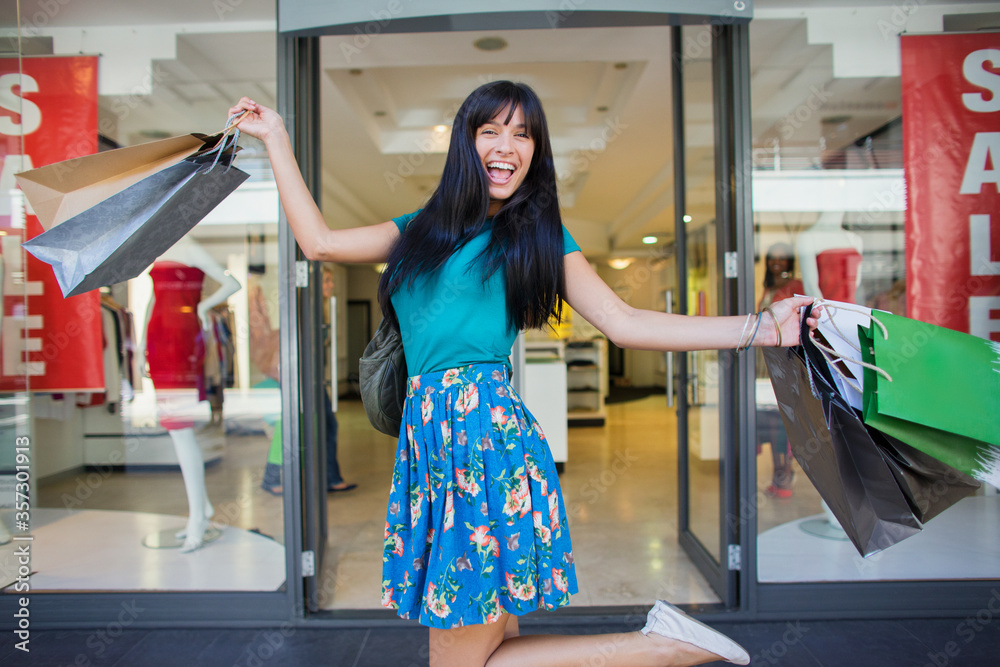 Canvas Prints Woman carrying shopping bags outside clothing store