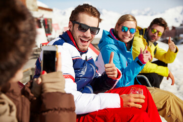 Obraz premium Woman taking pictures of friends in the snow