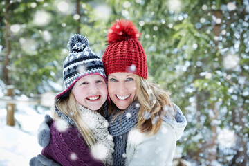 Fototapeta na wymiar Mother and daughter hugging in snow