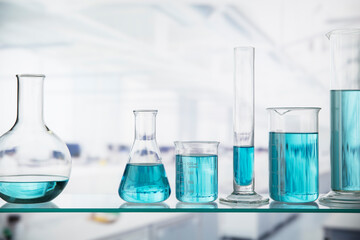 Close up of beakers with solution on shelf in lab