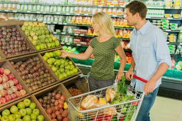 Couple shopping together in produce section of grocery store