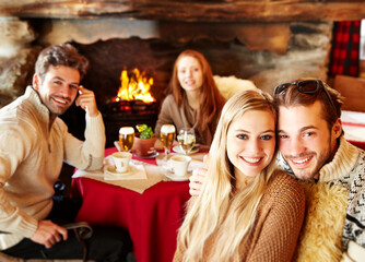 Friends eating together by fireplace