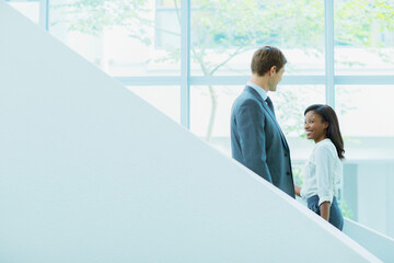 Business people crossing paths on staircase