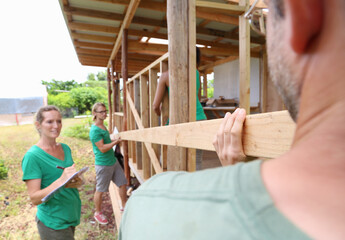 People building wooden house frame together