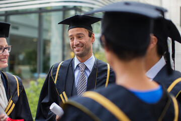 Students in cap and gown talking 