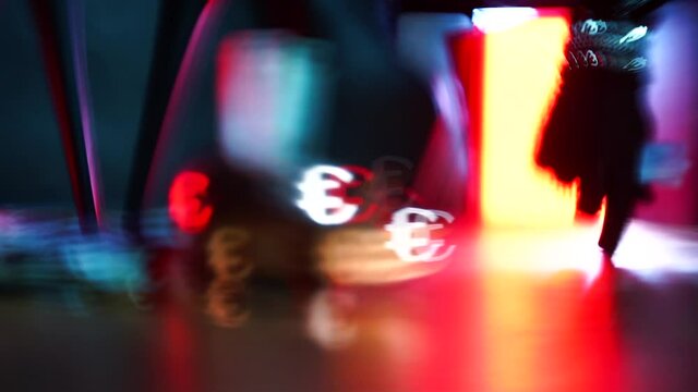 Effect of bokeh art production. A hand in the form of a silhouette of a man goes and puts a euro bill in piggy bank. In the background are giant high-heeled shoes. The concept of female domination.