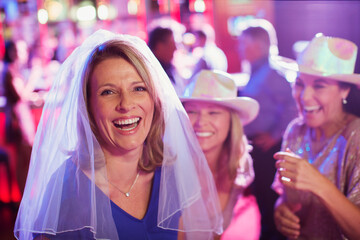 Women having fun at bachelorette party, men in background