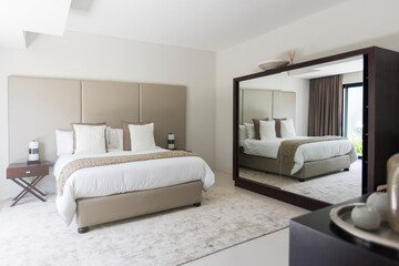 White and beige modern bedroom with double bed mirror